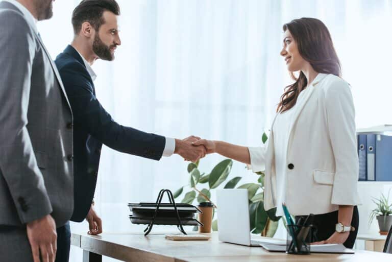 advisor and investor in suits shaking hands at office